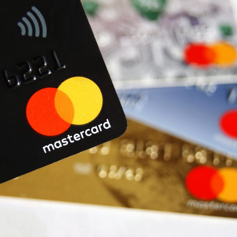 Zbliżenie na kilka kart kredytowych Mastercard w różnych kolorach, symbolizujących limity i zobowiązania
